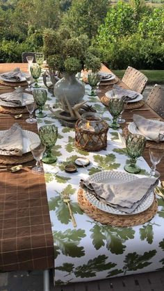 an outdoor table set with place settings and dishes for two people to enjoy the meal