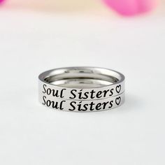 "This listing is for 2 stainless steel band rings, engraved with \"Soul Sisters\" + a heart symbol on the outside. It makes a lovely cute gift for best friends, forever sisters. Materials & Features: This ring is made of high quality hand polished solid stainless steel, which is hypoallergenic (good for metal-sensitive skin). Stainless steel will not tarnish, its luster and durability will make it last for many years. The black text on the ring will not fade out over time. Sizes: This ring is 3m Christmas Bridesmaids, Sisters Best Friends, Beeswax Taper Candles, Friend Bff, Sorority Sisters, Heart Symbol, Stacking Bands, Custom Personalized Gifts, Fade Out