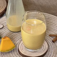 there is a glass and bottle next to some food on the table with other items around it