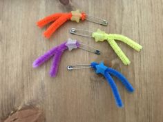 five different colored hair clips sitting on top of a wooden table