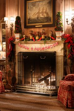 a fireplace decorated for christmas with presents around it