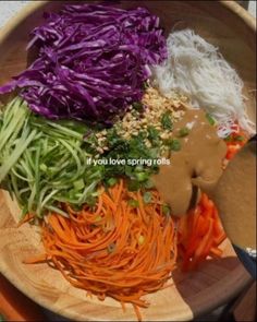 a wooden plate topped with lots of veggies and sauce