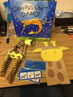 a giraffes can't dance book and craft supplies on a desk