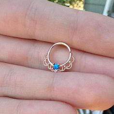 a person is wearing a gold ring with blue stones on the middle and an open band