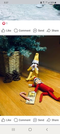 an elf is laying on the floor next to a christmas tree