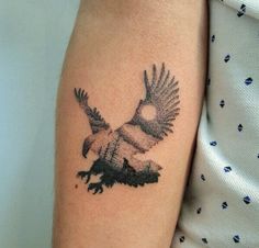 a bird tattoo on the arm of a woman