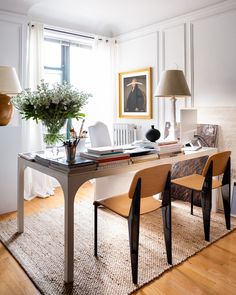 a table with two chairs and a vase filled with flowers