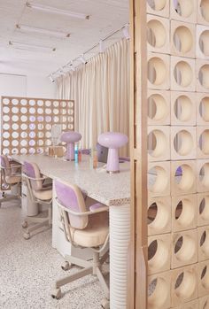 a room with several chairs and a table in front of a wall made out of circles