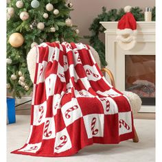 a red and white blanket sitting next to a christmas tree