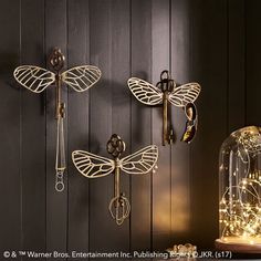 three dragonflys are mounted on the wall next to a glass dome with lights