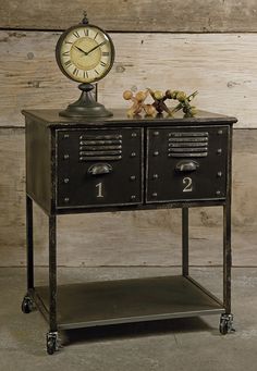 an old fashioned metal cabinet with two drawers and a clock on it's side