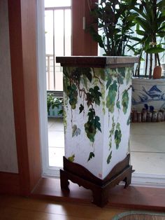 a potted plant sitting on top of a wooden stand in front of a door