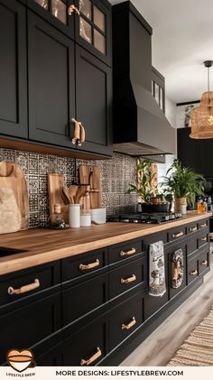 a kitchen with black cabinets and wooden counter tops, along with potted plants on the wall