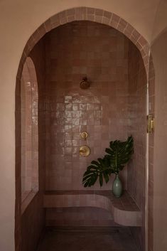 a bathroom with a plant in the corner and a quote on the wall above it