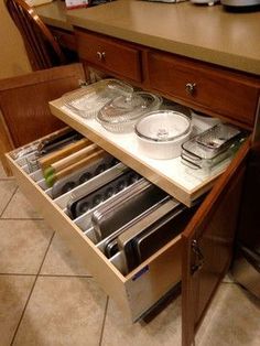 an open drawer in the middle of a kitchen