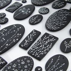 black and white painted rocks with flowers on them are arranged in a pattern that looks like snowflakes