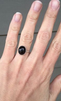 A lovely oval black onyx ring has been set in a simple sterling silver setting with a handmade ring band from sterling silver half dome wire. The stone is 12mm x 10mm in size with a height of about 8mm. This ring is simple and minimalist in style. Made to order! Simple Oval Sterling Silver Rings, Minimalist Oval Onyx Jewelry, Everyday Black Onyx Rings, Modern Black Oval Cabochon Jewelry, Black Oval Minimalist Jewelry, Simple Black Sterling Silver Jewelry, Minimalist Onyx Oval Ring, Minimalist Black Oval Rings, Boho Rocker