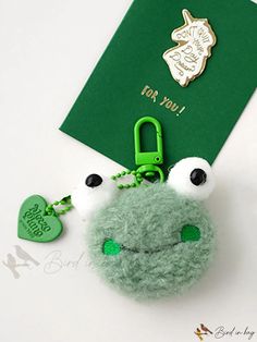 a keychain with a frog on it and a green tag attached to it