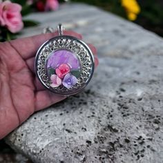 Music box pendant. This round music box is inspired by the gorgeous music box pendants of era's gone by. Music box is pill box size, please look at the dimensions for exact size. A perfectly round silvertone locket has been adorned with a layer of silver filigree A lacy edge filigree bezel with a lavender Clay insert featuring hand made flowers. The filigree and clay forals have been covered in a clear resin preserving the beauty of this musical pendant. The locket opens and closes by pushing th Music Box Locket, Photo Locket, Black Gift Boxes, Spring Vibes, Clear Resin, Music Lover, Silver Filigree, Music Box, Flower Making