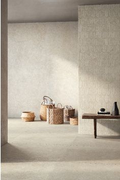 an empty room with several baskets on the floor and a table in front of it