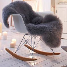 a white rocking chair with grey fur on it