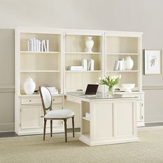 a white desk with a laptop on top of it next to a bookcase filled with books