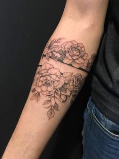 a woman's arm with flowers on it, and a black line in the middle