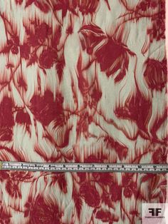 a red and white floral print fabric with a measuring tape in front of the image