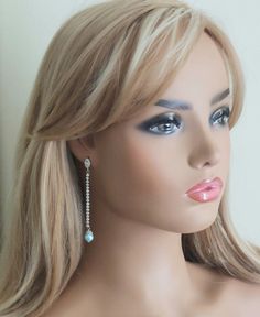 a mannequin head wearing earrings with blue eyes