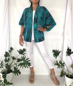 "100% Rayon Turquoise Teal Green with a hint of Grey Outer Jacket in abstract Batik Print.  This Outer Jacket design with kimono sleeve style Handmade by Balinese women in Bali.  A good pair with jeans and an elevated looks for your basics outfit.  The Size of this jacket is one fit for all sizes.  Please contact me if you need detail measurements This Kimono Jackets available in 6 different batik patterns option such as Teal Abstract (like shown on model), 4 petals blue green, Kenanga Green, Blue Vine Batik, Blue Yellow Batik and Greenery  Please kindly check my other listings for more batik pattern options Garment Measurements 60.96 cm Length (from high-point shoulder) x 152.4 cm Bust x 58.42 cm Sleeve (center neck to cuff) 24\" Length (from high-point shoulder) x 60\" Bust x 23\" Sleeve Blue Batik Print Beach Kimono, Beach Blue Batik Print Kimono, Bohemian Green Outerwear For The Beach, Casual Green Printed Outerwear, Green Summer Outerwear For Vacation, Green Long Sleeve Outerwear For Vacation, Green Open Front Top For Beach, Green Open Front Beach Cardigan, Green Open Front Cardigan For Beach