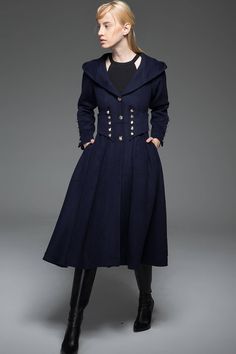 Crafted in warm wool, this navy military style wool long coat is designed to give an up-to-date and modern look with distinctive styling. This is outerwear that will make you stand out in the crowd. Wear this winter staple for perfect off-duty outfitting. The Military Coat features a gorgeous nipped in waist with button details. The hooded coat also has more button details on the cuffs and this detailing gives long hooded coat its military styling. The blue military coat has a fit and flare fit Hooded Pea Coat With Buttons For Fall, Hooded Pea Coat For Fall, Double-breasted Navy Pea Coat For Fall, Navy Double-breasted Pea Coat For Fall, Navy Double-breasted Peacoat With Button Closure, Winter Pea Coat With Button Cuffs, Hooded Pea Coat With Buttons For Workwear, Hooded Pea Coat For Workwear, Navy Wool Outerwear With Button Cuffs