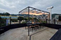 an outdoor dining area on top of a building with tables and chairs under umbrellas