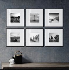 four black and white photographs hang on the wall above a table with a watering can