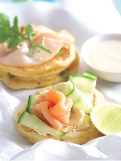 two small pastries with salmon and cucumber on them