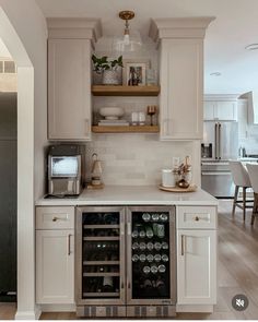 a kitchen with two wine coolers in the center and open shelves on the wall