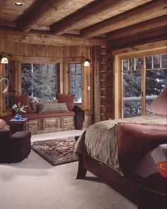 a bedroom with wood paneling and furniture in the corner, along with large windows