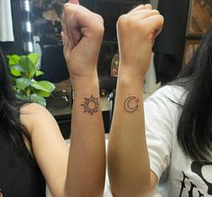 two girls with matching tattoos on their arms, one has the sun and the other has the moon