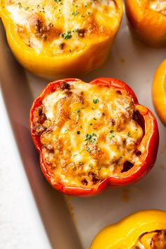 some stuffed peppers are sitting on a white tray and ready to be cooked in the oven