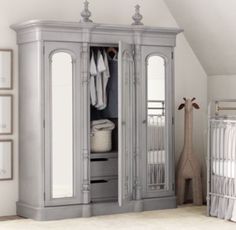 a baby's room with an armoire and crib