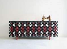 a black and red bench sitting on top of a white floor next to a gold statue