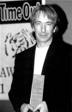 black and white photo of man holding award in hand