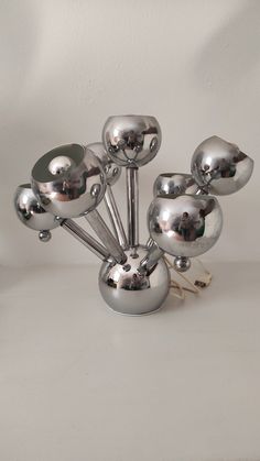 a bunch of silver balls sitting on top of a white table next to each other