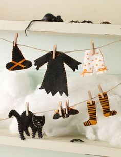 halloween decorations hanging from clothesline with cat and witch on the clothesline next to them