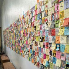 a wall covered in lots of different colored cards