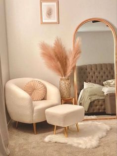 a bedroom with a mirror, chair and ottoman next to a bed in the corner