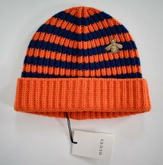 Brand: GUCCI PRODUCT SIZE: M/58/22cm Main color: orange/blue Details: A knitted wool beanie hat in contrasting stripes, subtly embellished with gold bee embroidery-a distinctive symbol of the house. The bee is an archival code first introduced in Gucci ready-to-wear in the 1970's.  Gold embroidered bee appliqué.  Orange and blue striped wool.  Made in Italy. Material: 100% wool.  Condition: new with tags.  100% authentic. United States: USPS Standard Mail - FREE SHIPPING Worldwide Shipping - cos Designer Beanie For Winter, Casual Gucci Hat With Embroidered Logo, Casual Gucci Cap, Embroidered Bee, Knitted Wool Beanie, Knitted Accessories, Best Amazon Buys, Bee Embroidery, Streetwear Accessories