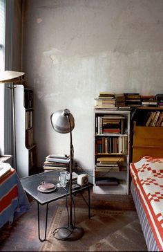 a bed room with a neatly made bed and a book shelf