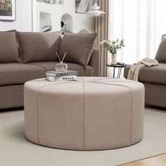 a living room with two couches and a round coffee table in the middle of it