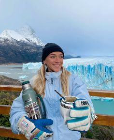 a woman holding two skis and a cup in her hands