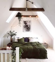 an attic bedroom with green bedding and candles